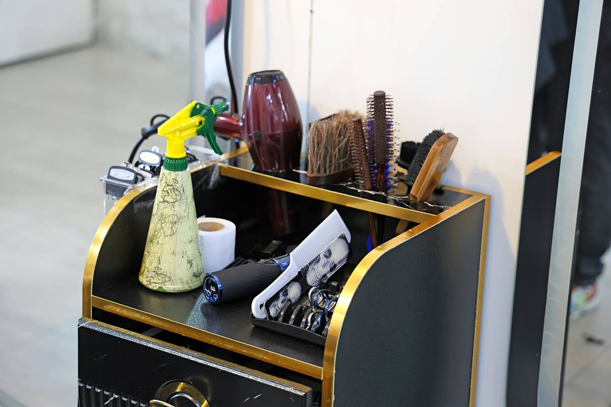 Woman applying hair spray before securing hair clips for all-day hold
